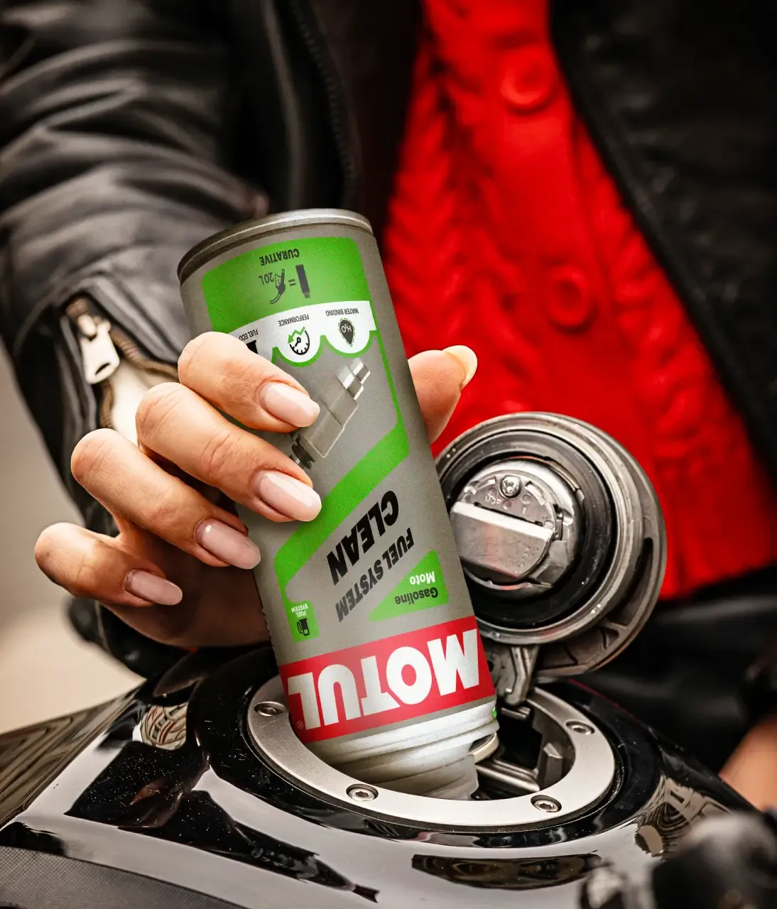 Rider holding a Motul Engine Clean can